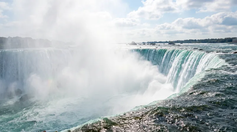 Water thundering over the brink of Horseshoe Falls with rising mist